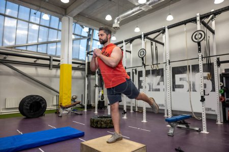 Téléchargez les photos : Jeune homme musclé fort faisant de l'entraînement avec une boîte en bois monter dans la salle de gym Crossfit. - en image libre de droit