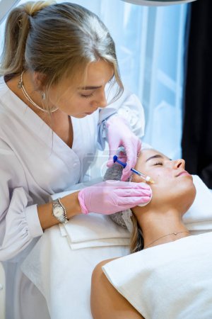 Foto de Cosmetólogo haciendo PRP ttherapy en clínica de belleza, haciendo la inyección, procedimientos antienvejecimiento. - Imagen libre de derechos