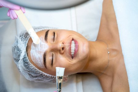 Téléchargez les photos : Esthéticienne professionnelle méconnaissable faisant des procédures de soins de la peau à la cliente. - en image libre de droit