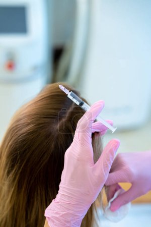 Téléchargez les photos : Mésothérapie. Médecin méconnaissable faisant des injections de vitamines dans la tête des clients peau de la zone de cheveux. - en image libre de droit