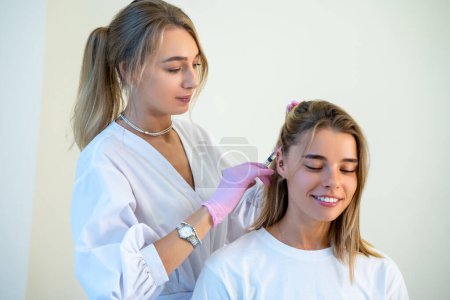 Photo for Specialist doing plasmolifting of scalp, stages of baldness, improving condition of hair, bio revitalization of hair skin, vitamins. - Royalty Free Image