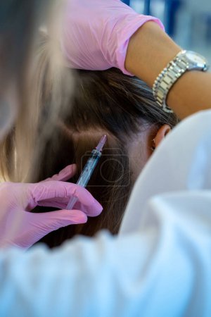Photo for Close up view of woman head and doctors hands with syringe, professional mesottherapy procedures, vitamin injections in hair area. - Royalty Free Image