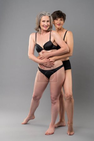 Téléchargez les photos : Des femmes en lingerie. Deux femmes âgées en lingerie balck debout à proximité - en image libre de droit
