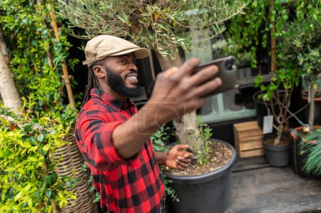 Photo for Selfie. Man in a red plaid shirt making a selfie on a greenery background - Royalty Free Image