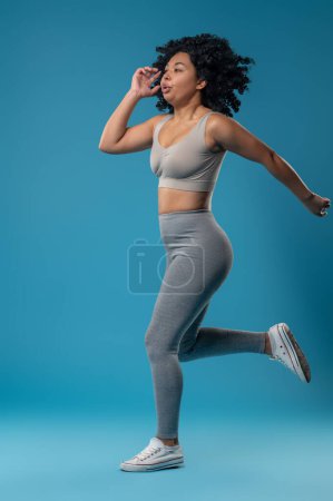 Foto de Energizado. Mujer bonita en ropa deportiva gris con aspecto energizado - Imagen libre de derechos