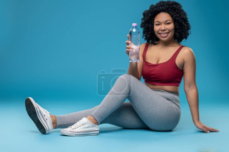 Téléchargez les photos : Water balance. Sporty woman in sportswear with a bottle of water - en image libre de droit