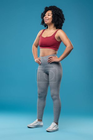 Téléchargez les photos : Athlète. Jeune femme sportive en tenue de sport sur fond bleu - en image libre de droit