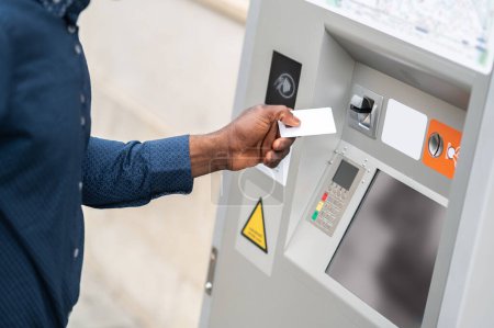 Photo for Retrieving money. Man retrieving cash from ATM in the street - Royalty Free Image