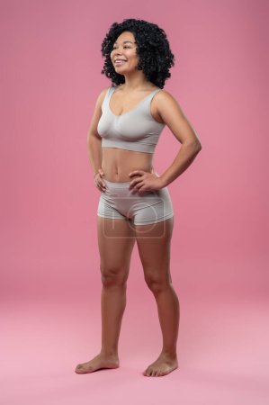 Téléchargez les photos : La force. Femme sportive en lingerie debout sur fond rose - en image libre de droit