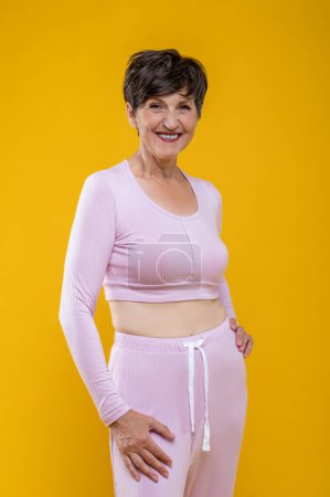 Foto de Humor positivo. Mujer mayor delgada en ropa rosa con aspecto positivo - Imagen libre de derechos