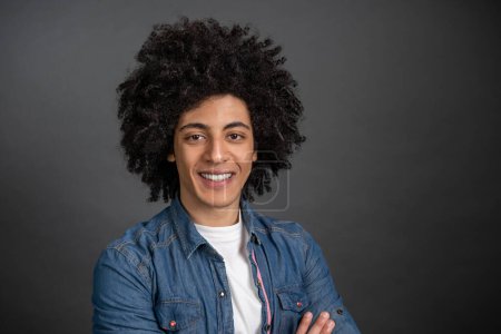 Photo for Young man. Waist up of a curly-haired young man on grey background - Royalty Free Image