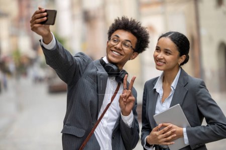 Téléchargez les photos : Selfie. Deux hommes d'affaires faisant selfie ensemble et regardant satisfait - en image libre de droit