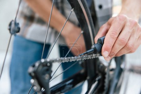 Téléchargez les photos : Réparation de vélos. Gros plan de mans mains réparant le système de transmission de vélo - en image libre de droit