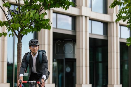 Foto de Área de oficina. Hombre montando una bicicleta en el área de la oficina - Imagen libre de derechos