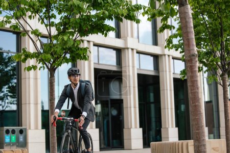 Foto de Camino a la oficina. Hombre en dobladillo en una bicicleta en el área de la oficina - Imagen libre de derechos