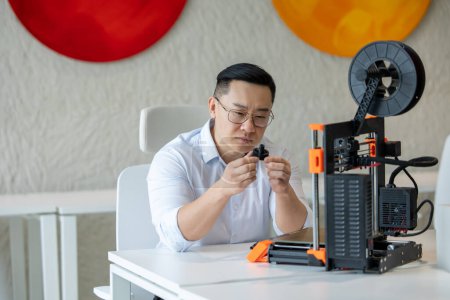 Foto de Diseñador masculino asiático usando impresora 3D en la oficina, trabajando con nuevas ideas de tecnología. - Imagen libre de derechos