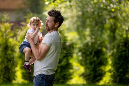 Photo for Dad and son. Happy young dad playing with his son and looking contented - Royalty Free Image