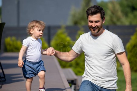 Photo for Morning walk. Dad and son having a walk and looking contented - Royalty Free Image