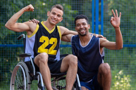 Téléchargez les photos : Homme caucasien en fauteuil roulant jouant au basket avec un ami au tribunal extérieur, agitant les mains. - en image libre de droit