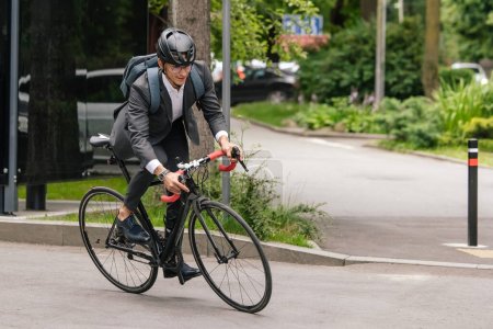 Foto de En el camino. Hombre en hemlet protector montar una bicicleta en el camino - Imagen libre de derechos