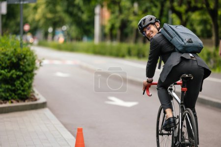 Téléchargez les photos : Sur un vélo. Le gestionnaire se rend au bureau à vélo - en image libre de droit