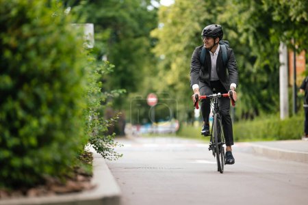 Téléchargez les photos : Sur un vélo. Le gestionnaire se rend au bureau à vélo - en image libre de droit