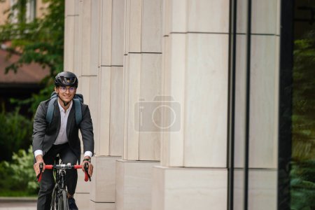 Photo for Morning ride. Businessman riding a bike and looking contented - Royalty Free Image