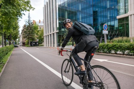 Foto de Camino a la oficina. Joven montando en bicicleta en un centro de la ciudad - Imagen libre de derechos