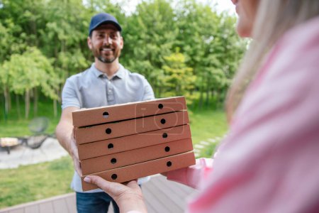 Foto de Mensajero hombre express entrega de comestibles a cliente femenino, la entrega de pizza. - Imagen libre de derechos