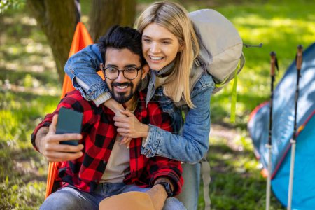 Photo for Selfie in the forest. Cute couple making selfie in the forest on a tent background - Royalty Free Image