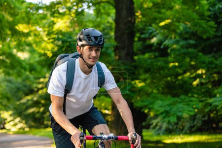 Photo for In the park. Cyclist on a bike on the road in the park - Royalty Free Image