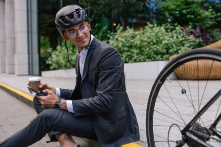 Photo for Coffee before work. Young man having coffee after commuting to the office by bike - Royalty Free Image