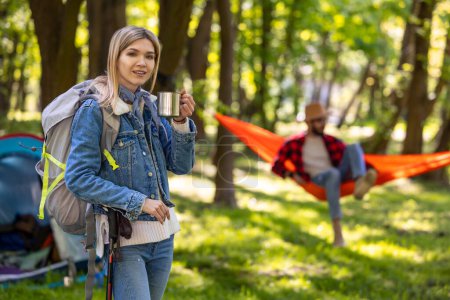 Photo for In the forest. Blonde young girl with backpack on the greenery background in the forest - Royalty Free Image