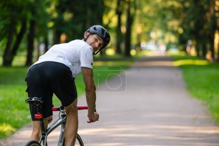Téléchargez les photos : Cycliste. Jeune cycliste bien construit sur un vélo à l'air confiant - en image libre de droit