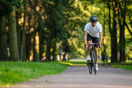 Téléchargez les photos : En balade. Jeune cycliste masculin en vélo dans la forêt - en image libre de droit