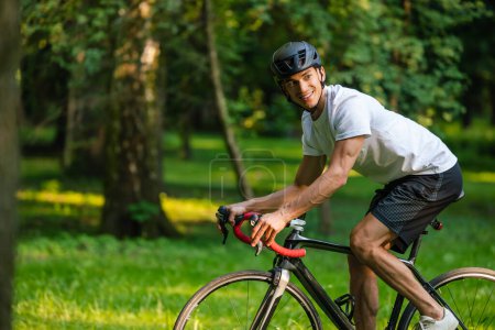 Téléchargez les photos : Faire du vélo. Homme en vêtements de sport en vélo et l'air excité - en image libre de droit
