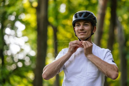 Foto de Hemlet protector. Joven ciclista guapo poniéndose su dobladillo protector - Imagen libre de derechos