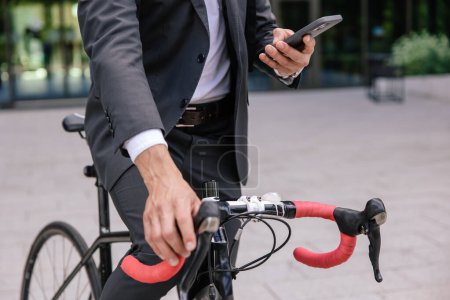 Foto de Alquilar una bicicleta. Hombre utilizando la aplicación móvil y desbloquear el estacionamiento - Imagen libre de derechos