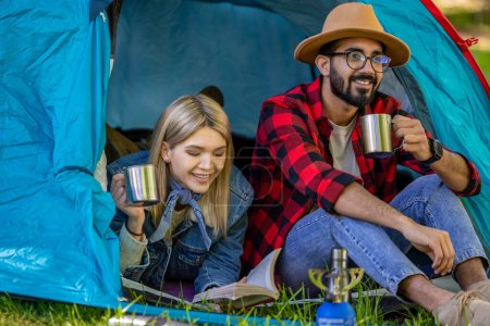 Téléchargez les photos : Mode voyage. Jeune couple de voyageurs dans la tente se sentant détendu - en image libre de droit