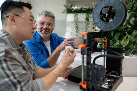 Téléchargez les photos : Deux scientifiques impliqués dans la mise en place et le développement d'imprimantes 3D dans le laboratoire moderne. - en image libre de droit