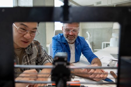 Téléchargez les photos : Collèges ingénieurs travaillant avec le processus d'impression de l'imprimante 3D. - en image libre de droit