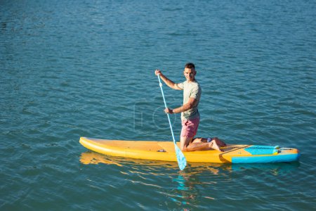Photo for Athletic man on sub board floating on ocean sea. - Royalty Free Image