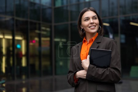 Téléchargez les photos : Nouveau lieu de travail. Jeune femme mignonne avec un gadget dans la zone de bureau à la recherche satisfait - en image libre de droit