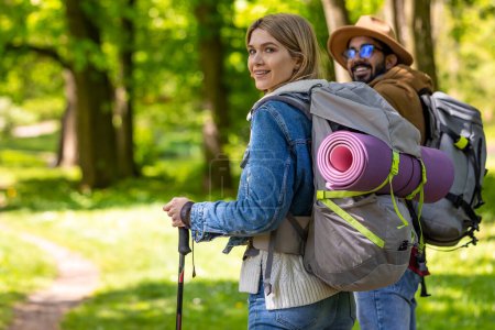 Foto de Viajeros. Viajeros con mochilas y palos escandinavos en el bosque - Imagen libre de derechos