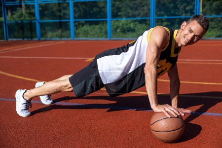 Photo for Caucasian athletic attractive man training on basketball court. - Royalty Free Image