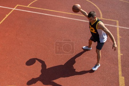 Photo for Athletic male sportsman playing basketball throwing ball at playground, copy space. - Royalty Free Image