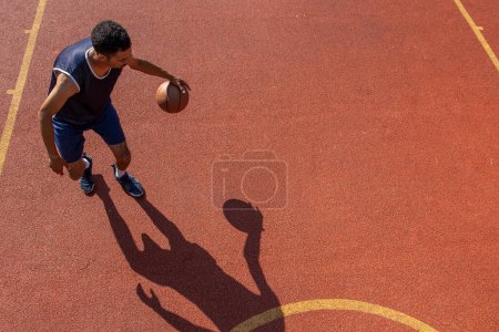 Téléchargez les photos : Basket-ball d'entraînement d'homme athlétique au terrain extérieur, espace de copie. - en image libre de droit