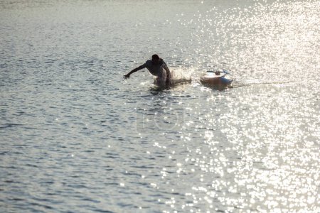 Téléchargez les photos : Silhouette d'homme tombant de supboard dans l'eau. - en image libre de droit