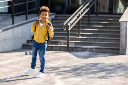 Photo for On the way home. Schoolboy with backpack going home from school - Royalty Free Image