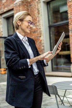 Photo for Business woman. Trendy young woman in balck with a tablet in the office area - Royalty Free Image